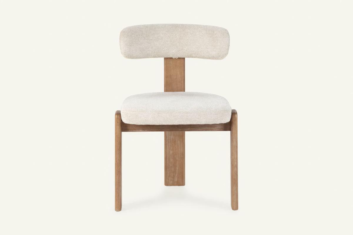 The Orta Dining Chair in ivory, upholstered dining chair on a wooden frame, studio view