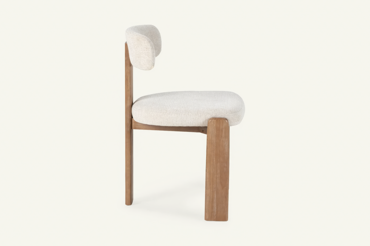 The Orta Dining Chair in ivory, upholstered dining chair on a wooden frame, studio view