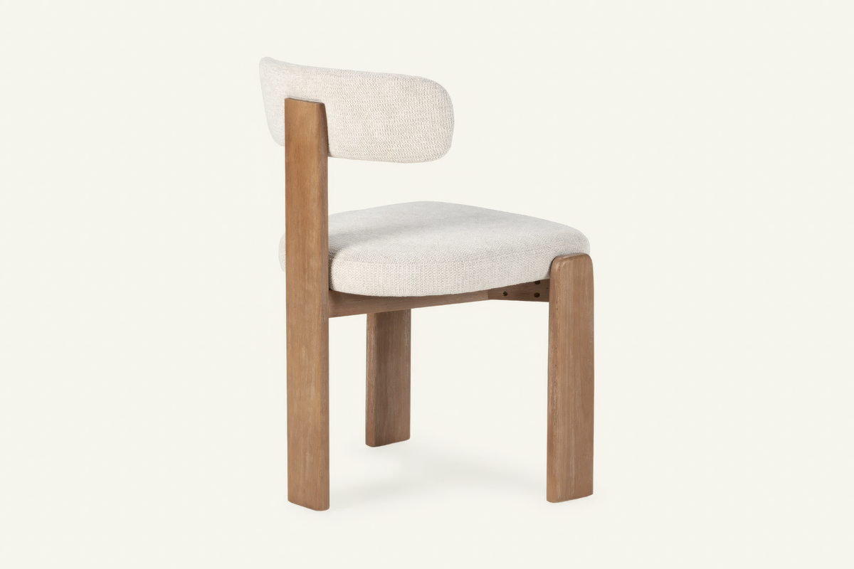 The Orta Dining Chair in ivory, upholstered dining chair on a wooden frame, studio view