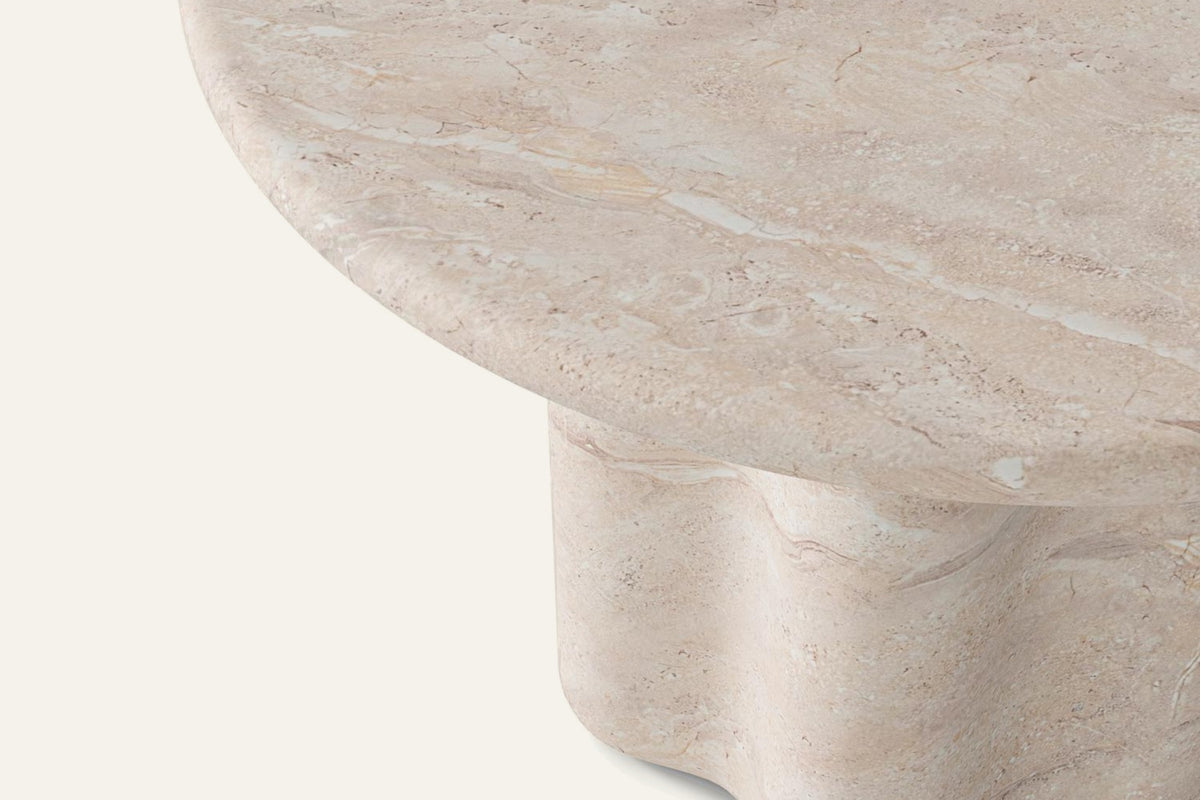 The Ortigia Travertine Finish Round Dining Table, close-up of the travertine-finish top and wave base