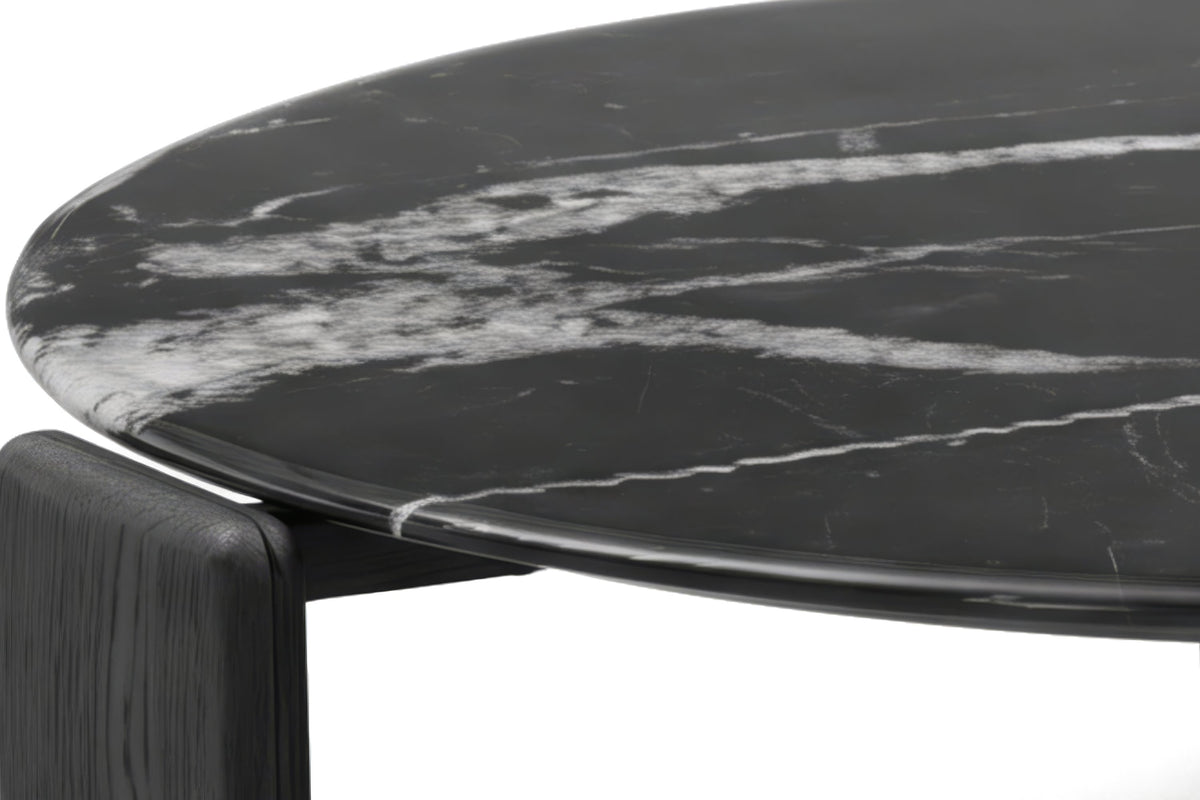 The Ostia Marble Coffee Table, close-up of the black marble top and curved oak leg