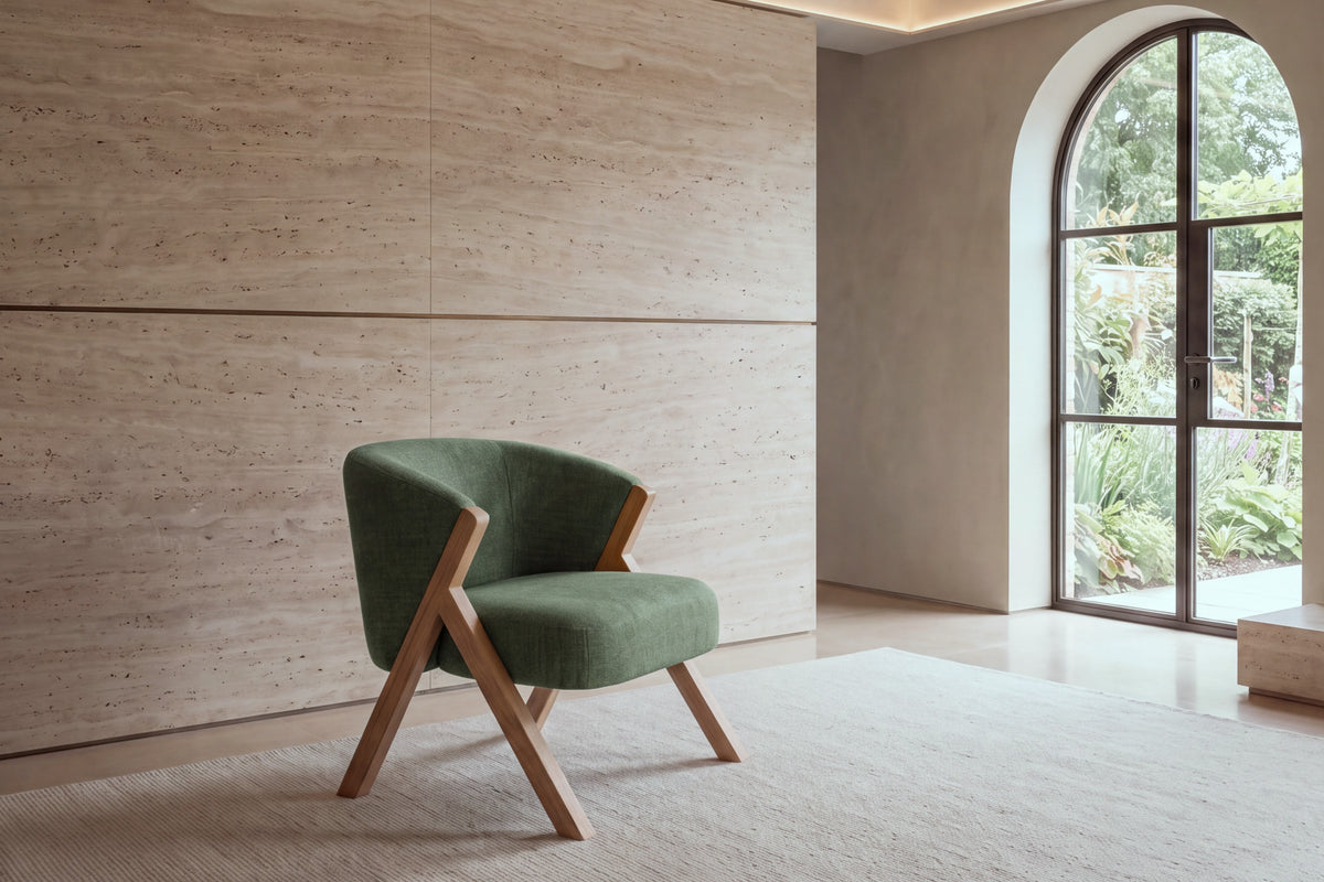 The Pizzo armchair in green boucle against a travertine wall