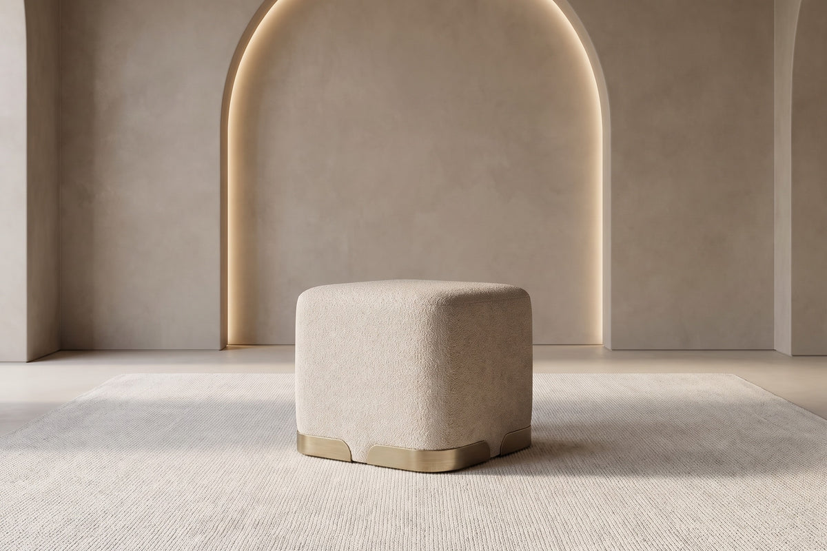 The Sabbia Pouf in oatmeal boucle in a warm plaster room