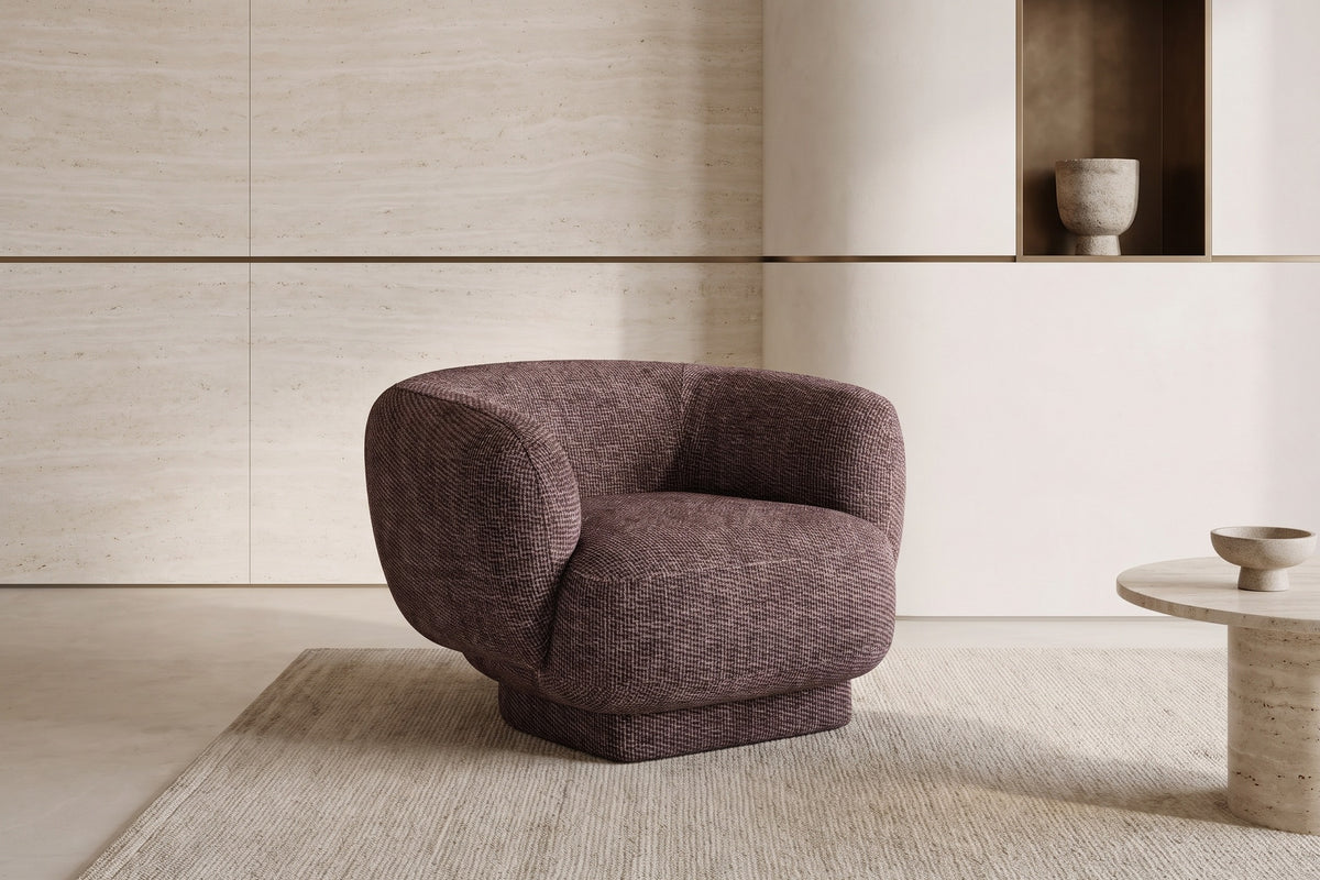 The Salina Armchair in burgundy boucle in a pale plaster room