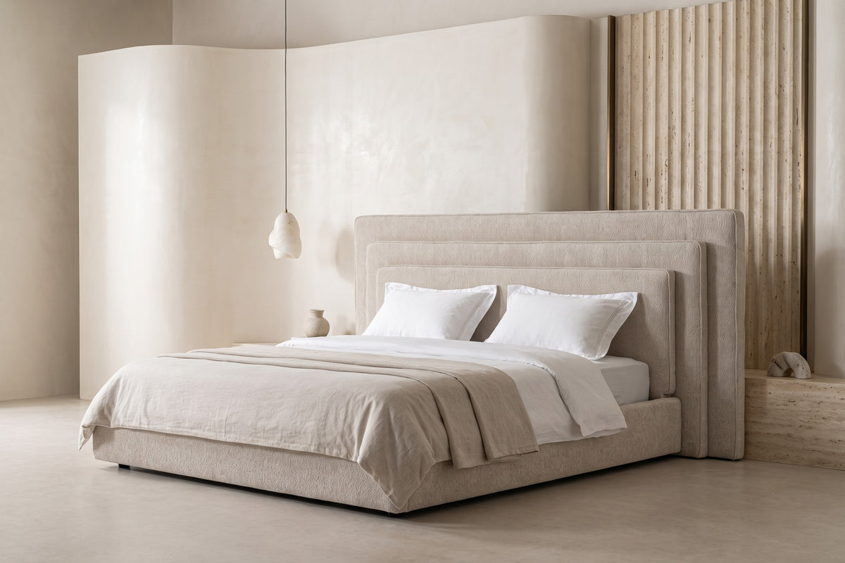 The Siracusa Bed with a tall layered headboard in a plaster bedroom