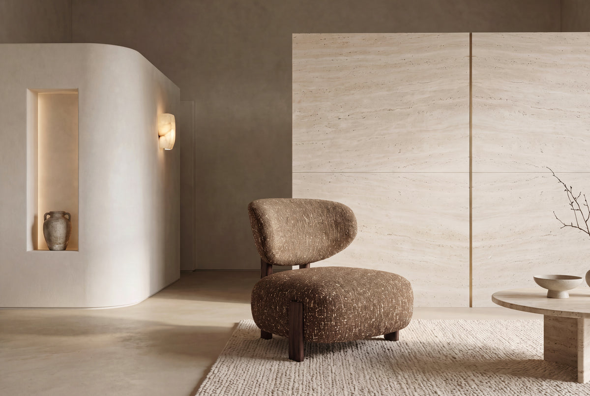 The Sirmione Lounge Chair in brown boucle on a walnut frame, in a travertine and plaster living room