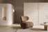 The Sirmione Lounge Chair in brown boucle on a walnut frame, in a travertine and plaster living room