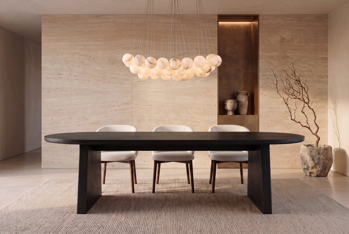 The Sutri Oval Dining Table in black, oval dining table on panel legs, styled in a room