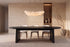 The Sutri Oval Dining Table in black, oval dining table on panel legs, styled in a room