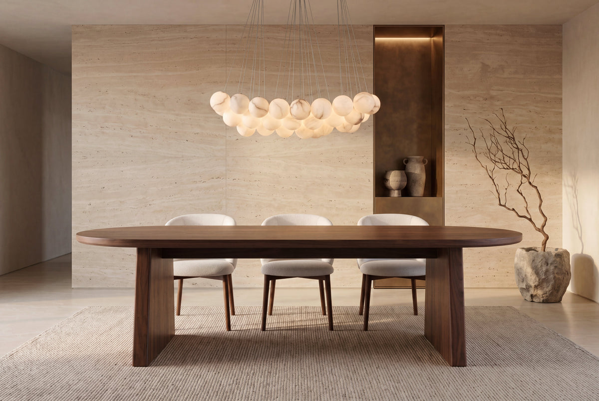 The Sutri Oval Dining Table in walnut, oval dining table on panel legs, styled in a room