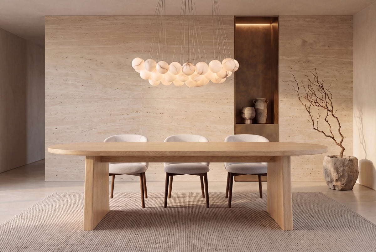 The Sutri Oval Dining Table in natural, oval dining table on panel legs, styled in a room