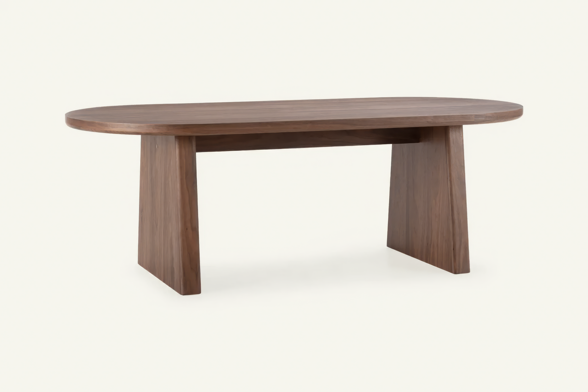 The Sutri Oval Dining Table in walnut, oval dining table on panel legs, studio view