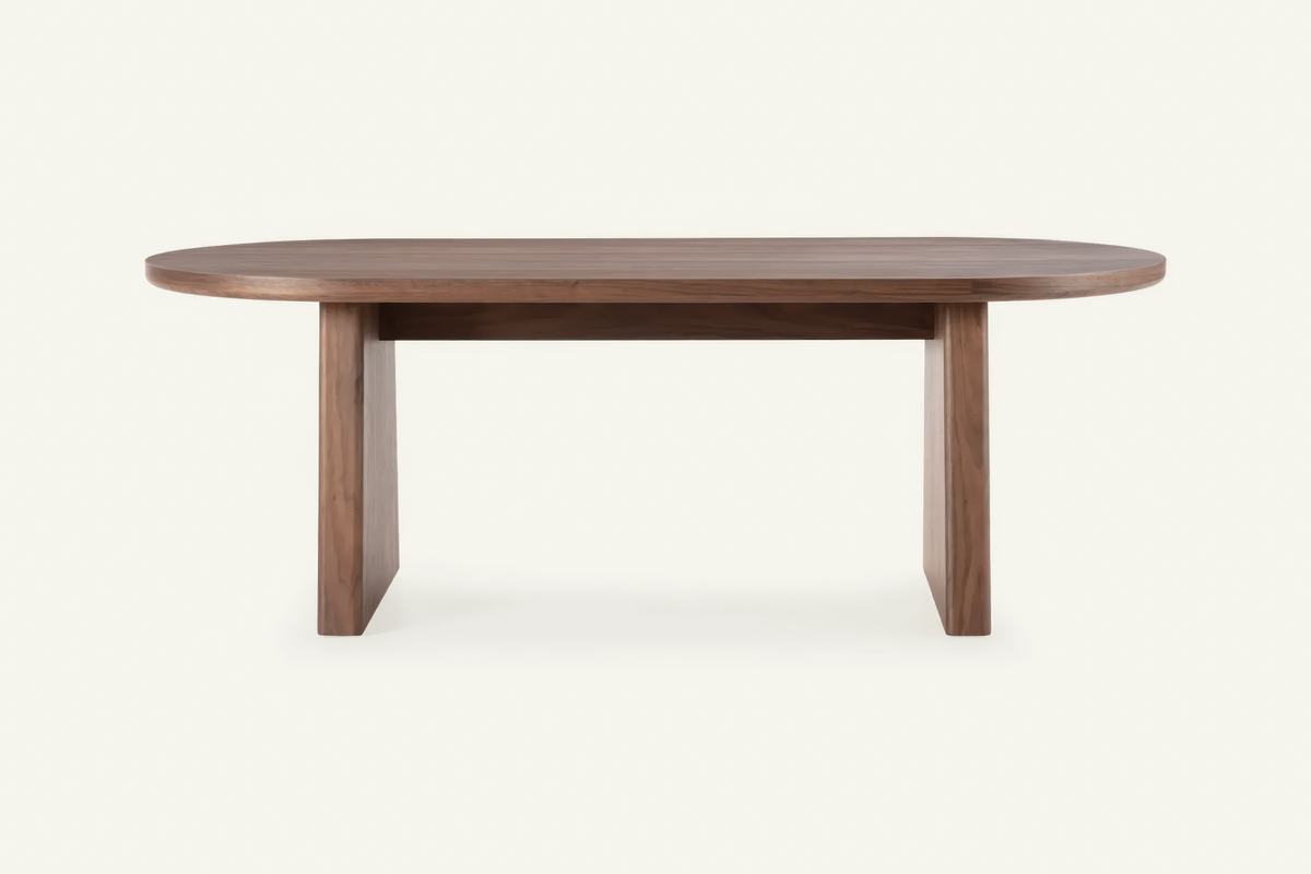 The Sutri Oval Dining Table in walnut, oval dining table on panel legs, studio view