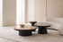 The Trani Coffee Table Set in travertine and black oak in a pale living room with an ivory sofa