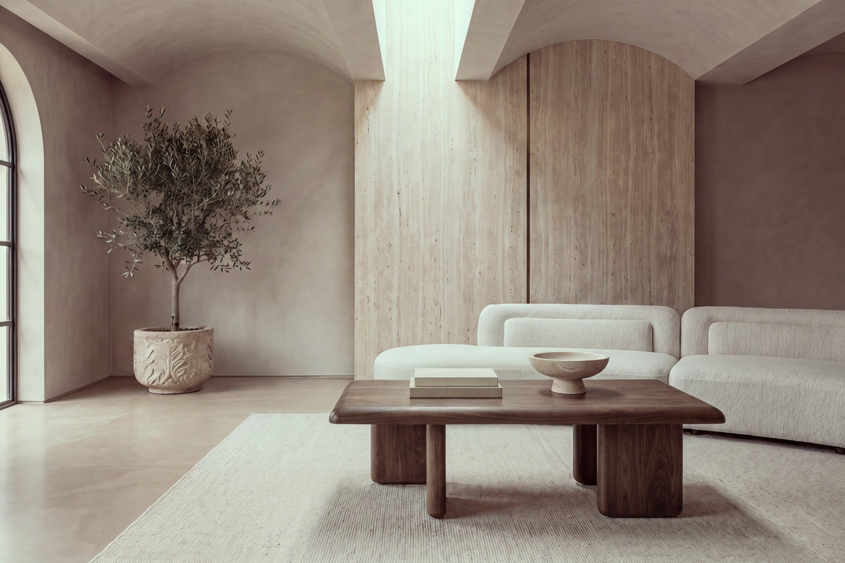 The Tremezzo Coffee Table in walnut in a barrel-vaulted living room with a travertine wall and an ivory boucle sofa