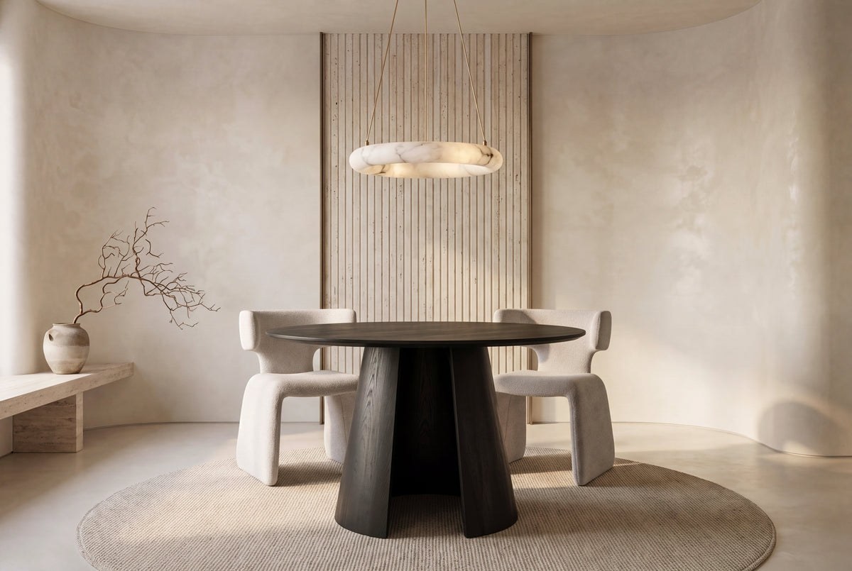 The Tropea Round Dining Table in black, round dining table on a curved panel pedestal, styled in a room