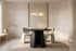 The Tropea Round Dining Table in black, round dining table on a curved panel pedestal, styled in a room