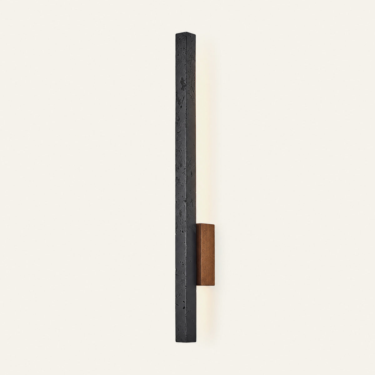 The Lama travertine wall light in black travertine, lit