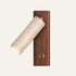 The Lettura travertine wall light with a walnut backplate