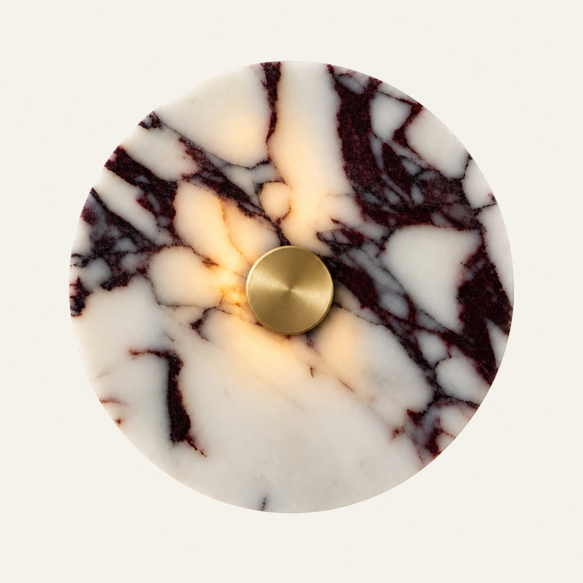 The Marmo marble wall light in Viola marble, lit