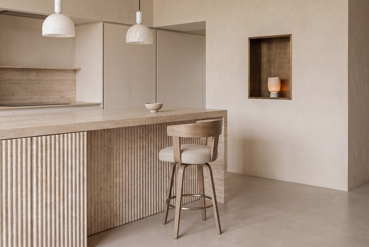 The Novara Swivel Bar Stool in beige and washed oak at a fluted travertine kitchen island beneath Cupola alabaster pendants
