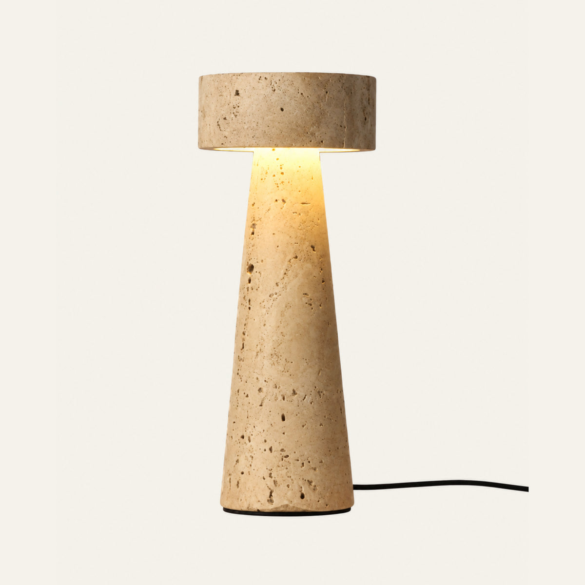 The Obelisco travertine table lamp, a tapered stone column with a stone cap