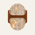 The Ponticello travertine wall light, a rounded stone slab crossed by a walnut bridge