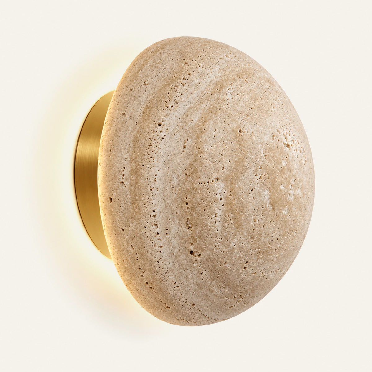 The Sole travertine wall light with a soft halo of light