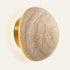 The Sole travertine wall light with a soft halo of light