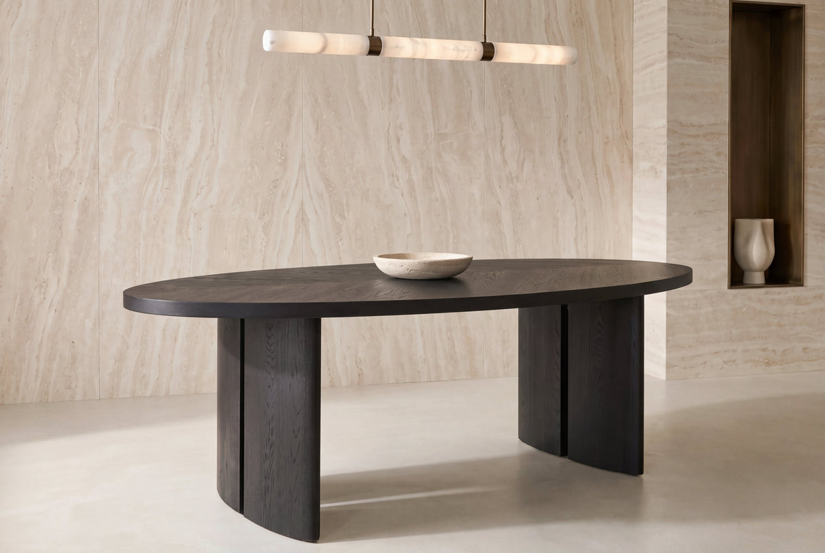The Arezzo Oval Dining Table beneath an alabaster pendant in a travertine dining room