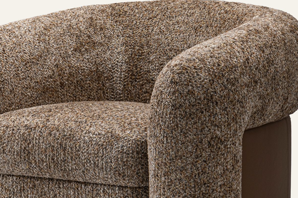 The Belluno Accent Chair, close-up of the textured bouclé arm and leather side panel