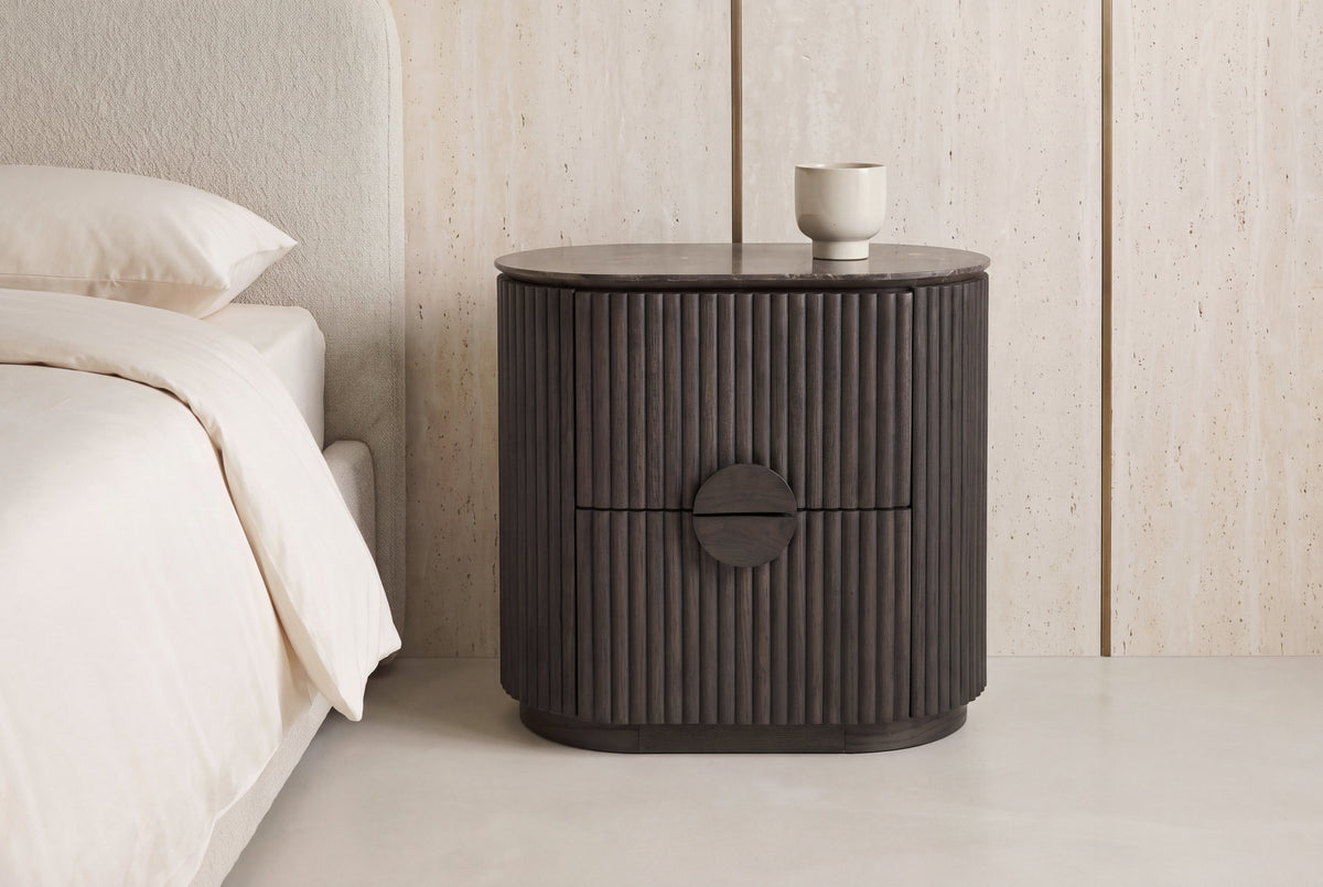 The Bevagna Fluted Marble Bedside Table in a bedroom setting