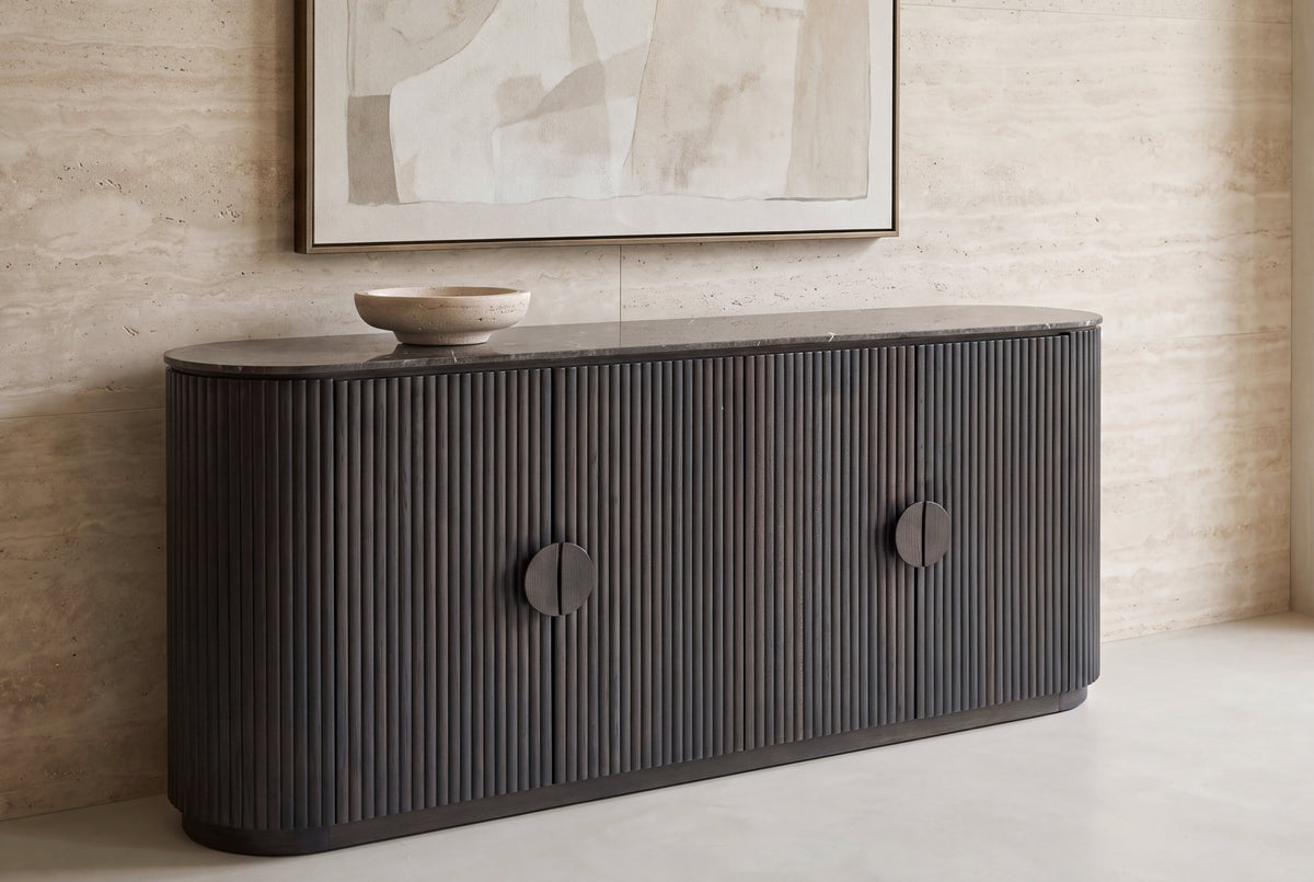 The Bevagna Fluted Marble Sideboard against a travertine wall