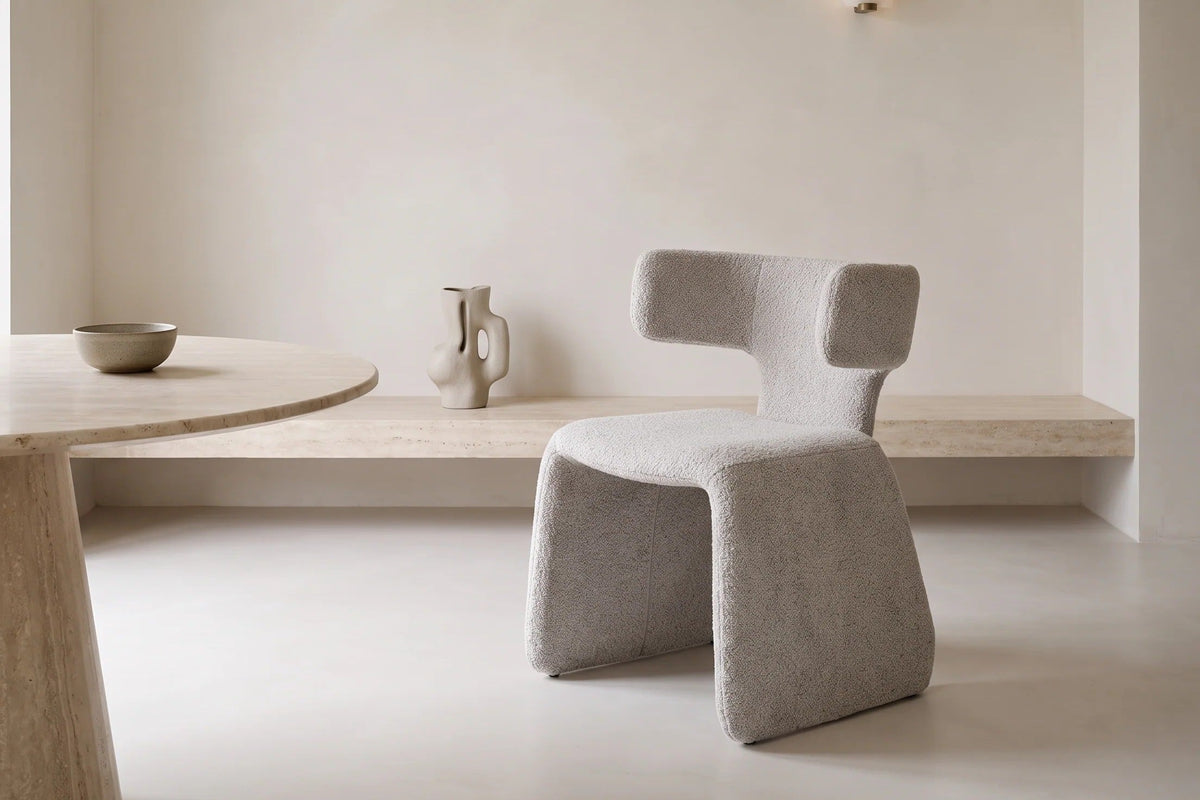 The Cetona Dining Chair beside a travertine dining table