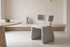 The Cetona Dining Chair beside a travertine dining table