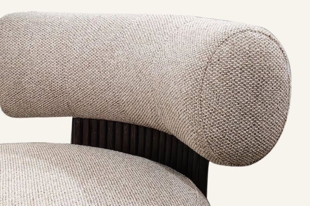 The Cortona Swivel Chair in warm beige, bolster and fluted back detail
