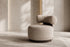 The Cortona Swivel Chair in warm beige textured weave in a limewashed gallery room