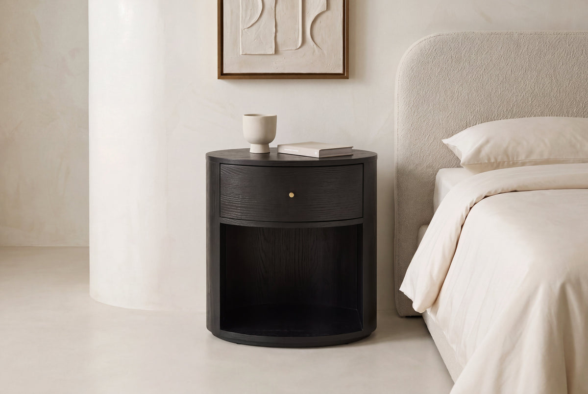 The Ostuni Black Oak Bedside Table in a bedroom setting