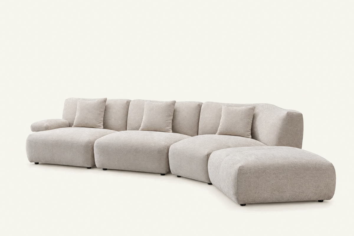 The Solaro Modular Sofa in oatmeal chenille with matching cushions, curved configuration with ottoman, angled view