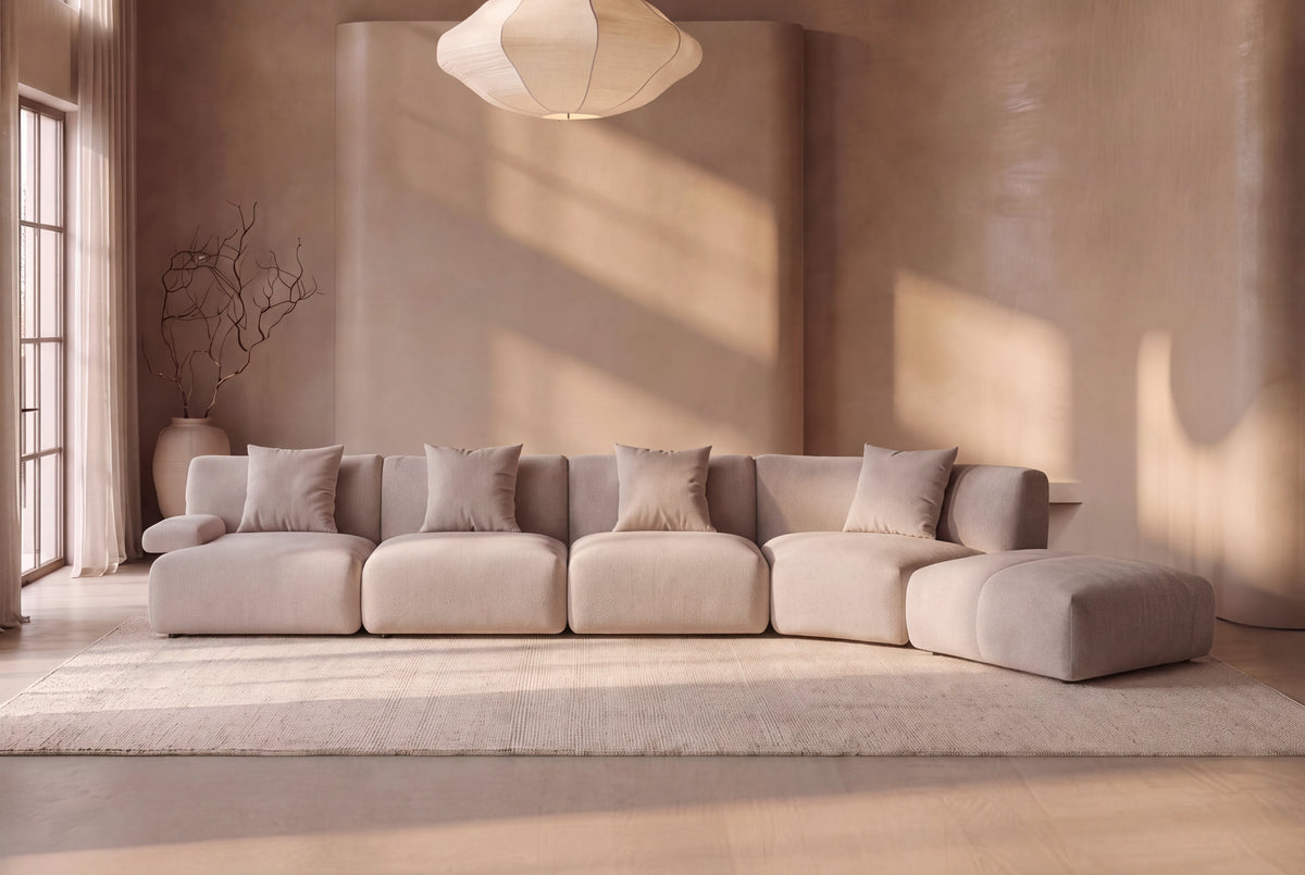 The Solaro Modular Sofa in oatmeal chenille in a plaster-walled living room with tall windows