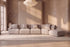 The Solaro Modular Sofa in oatmeal chenille in a plaster-walled living room with tall windows