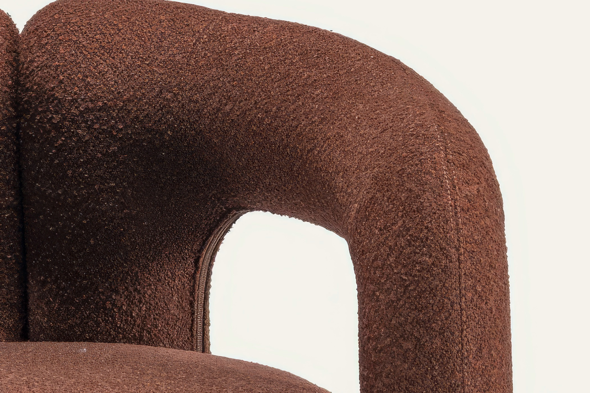 The Terracina Accent Chair, close-up of the rust bouclé arm and seat