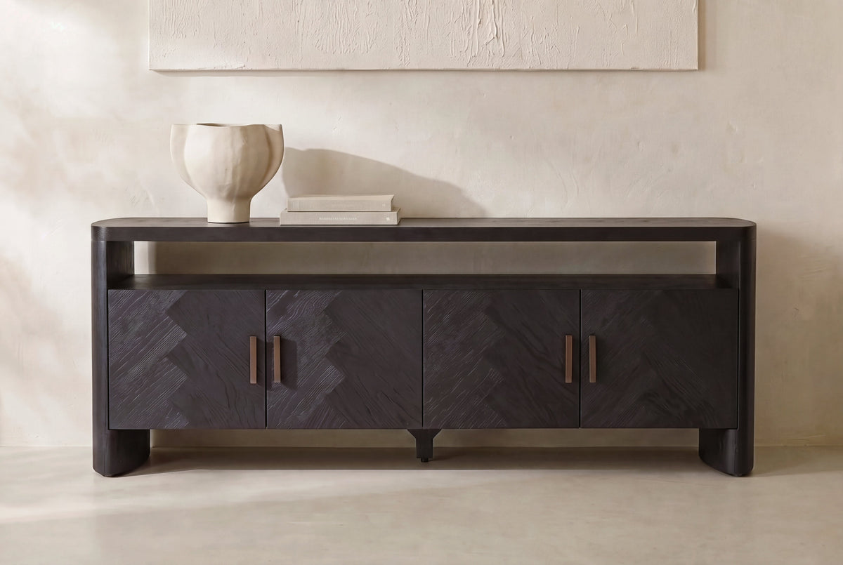 The Todi Herringbone Sideboard against a plaster wall