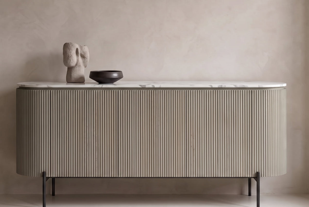 The Urbino Slatted Stone Sideboard against a plaster wall