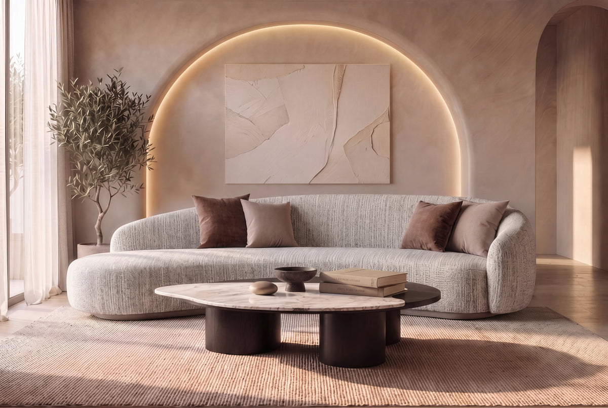 The Varenna Sofa with The Caldera Coffee Table and the Ligne de Terre canvas artwork in a lit plaster arch