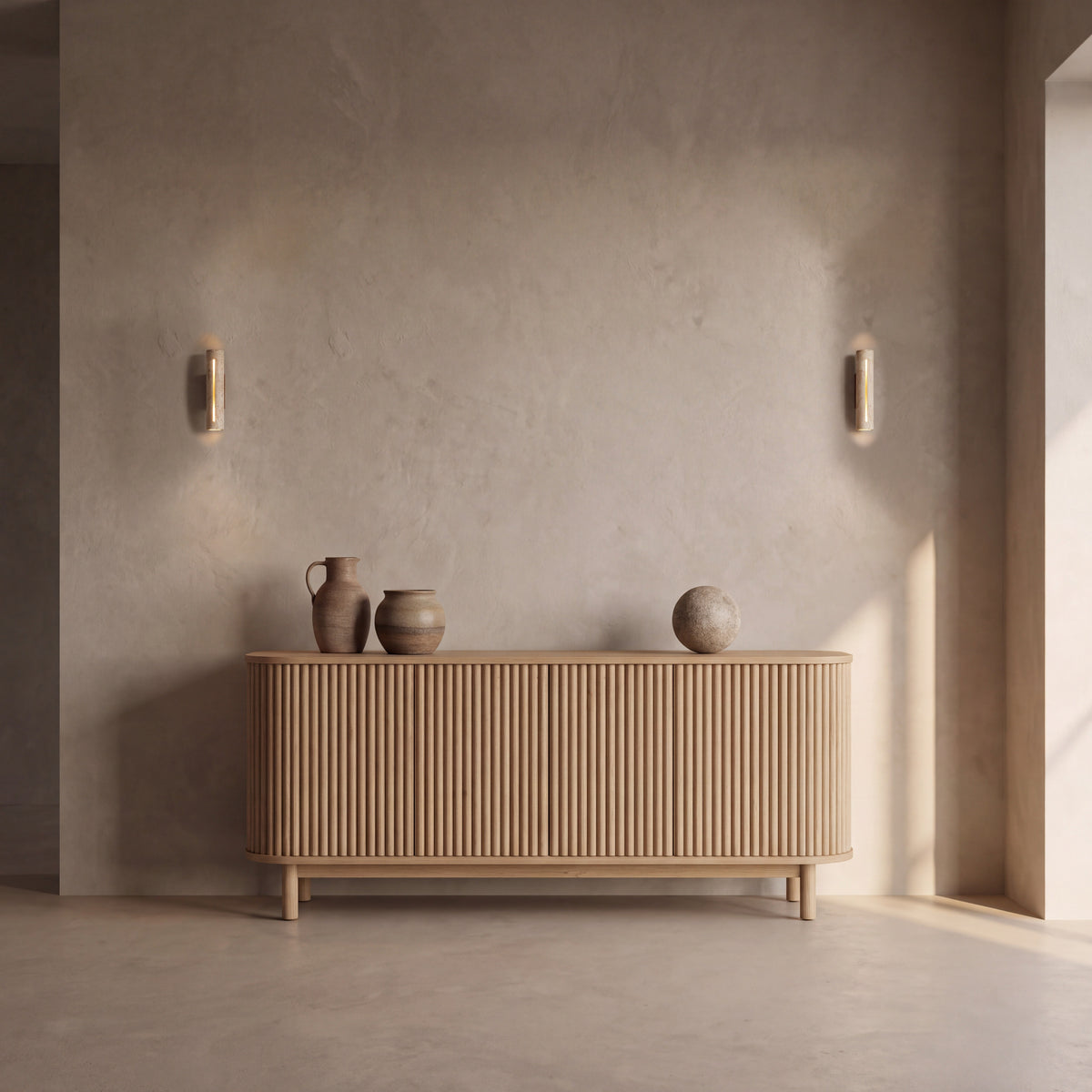 A pair of Tronco travertine wall lights either side of a fluted oak sideboard