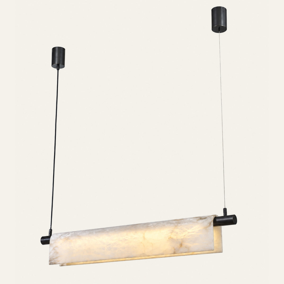 The Vela alabaster linear pendant light, a curved stone panel with black end caps