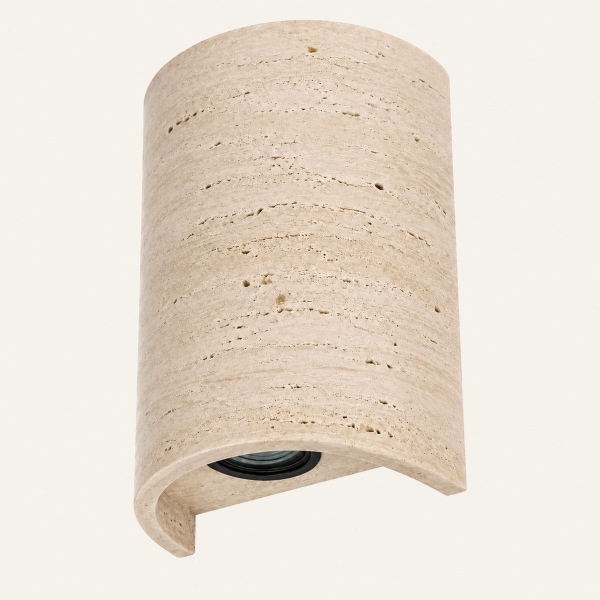 The Volta travertine wall light, a curved stone shade