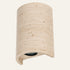 The Volta travertine wall light, a curved stone shade